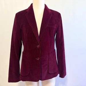 May include: A burgundy corduroy blazer with two button closures and two front pockets.