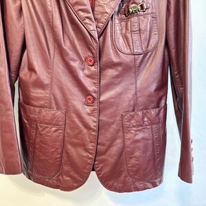 Pode incluir: Um blazer de couro bord&ocirc; com fecho de um s&oacute; bot&atilde;o e dois bolsos com aba. O blazer tem um detalhe met&aacute;lico decorativo no lado esquerdo do peito.