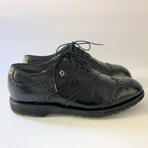 May include: Black leather brogue shoes with a wingtip design and a lace-up closure.