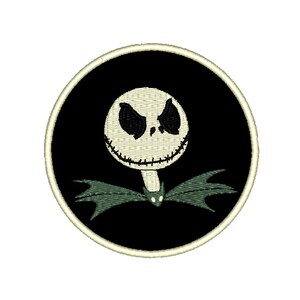 May include: A black and white embroidered patch with a round shape. The patch features a cartoon face with a stitched smile and black eyes. The face is surrounded by a green bow tie and wings.