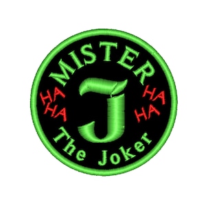 Puede incluir: Un parche circular verde y negro con el texto "Mister J The Joker" y "HA HA" a cada lado de la letra "J".
