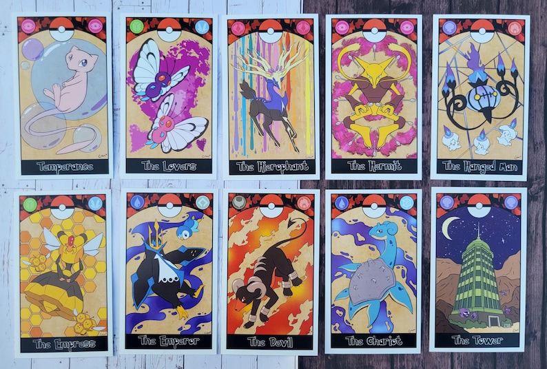 May include: Ten tarot cards featuring Pokemon characters. Each card has a different Pokemon and a tarot card name. The cards are on a wooden surface.