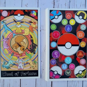 May include: Two cards with a Pokemon theme. The first card features a colorful wheel with a Pokeball in the center and various Pokemon characters around the wheel. The text "Wheel of Fortune" is at the bottom of the card. The second card features a red and black background with a Pokeball in the center and various Pokemon symbols around the Pokeball.