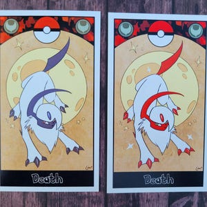 May include: Two cards with a white background and black borders. Each card features a stylized illustration of a white creature with a red or purple horn. The creature is standing on a yellow moon with stars. The text "Death" is printed at the bottom of each card.