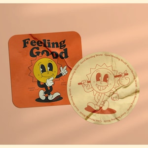 Puede incluir: Dos pegatinas de estilo vintage con un personaje de sol de dibujos animados. La primera pegatina es naranja y dice "Feeling Good" con un personaje de sol que lleva corbata y se toca la barbilla con un dedo. La segunda pegatina es amarilla y dice "Good Morning World" con un personaje de sol que lleva un palo y una bolsa.