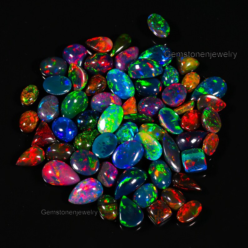 May include: A collection of iridescent opal gemstones in various shapes and sizes. The opals display a rainbow of colors, including green, blue, red, and purple.