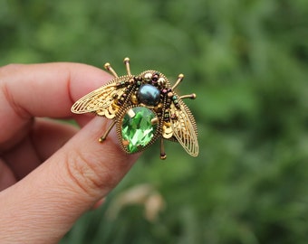 Fliegenbrosche klein mit metallenen Flügeln