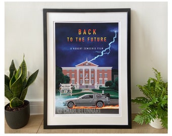 Könnte beinhalten: Ein gerahmtes Poster des Films Zurück in die Zukunft. Das Poster zeigt einen blauen Himmel mit einem Blitz, ein Gebäude mit einem Uhrturm und einen DeLorean, der vom Gebäude wegfährt. Der Text "Zurück in die Zukunft" ist in roten und gelben Buchstaben, und der Text "Ein Film von Robert Zemeckis" ist in weißen Buchstaben. Das Poster ist signiert mit "@charlielunnart".