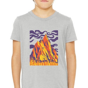 May include: A gray t-shirt with a graphic of a mountain range in shades of orange, yellow, purple, and blue. The mountain range is set against a purple sky with white clouds.