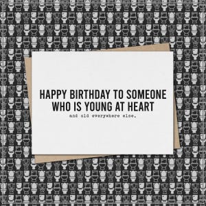 May include: A birthday card with the message "HAPPY BIRTHDAY TO SOMEONE WHO IS YOUNG AT HEART and old everywhere else." The card is on a brown envelope, set against a black and white toilet pattern background.