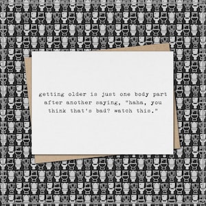 May include: A greeting card with a white rectangular insert and a brown envelope. The card has the text: "getting older is just one body part after another saying, 'haha, you think that's bad? watch this.'" The background is a black and white toilet pattern.