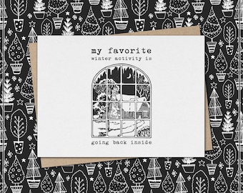 Könnte beinhalten: Eine Grußkarte mit dem Text "my favorite winter activity is going back inside." Die Karte zeigt eine Schwarz-Weiß-Illustration einer Fensterszene mit einer Winterlandschaft. Der Hintergrund ist ein schwarzes Muster aus Topf-Weihnachtsbäumen.