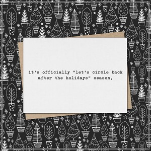 May include: A white greeting card with the text "it's officially "let's circle back after the holidays" season." is placed on a brown envelope. The background is a black and white pattern of Christmas trees.