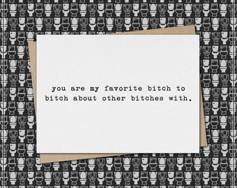 May include: A greeting card with the text "you are my favorite bitch to bitch about other bitches with." The card is white with a brown envelope, set against a black and white toilet pattern background.