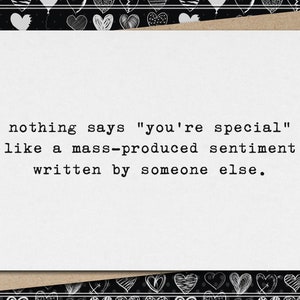May include: A greeting card with a white background and a brown envelope. The card has the text: "nothing says 'you're special' like a mass-produced sentiment written by someone else." The border is black with white hearts.