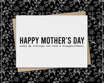 Puede incluir: Una tarjeta de felicitación rectangular blanca con texto negro que dice HAPPY MOTHER'S DAY y sorry my siblings are such a disappointment. La tarjeta está colocada sobre un sobre marrón contra un fondo negro con un patrón floral blanco.