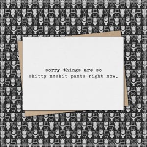 May include: A white greeting card with the text "sorry things are so shitty mcshit pants right now." is placed on a brown envelope. The background features a repeating pattern of black and white toilet illustrations.