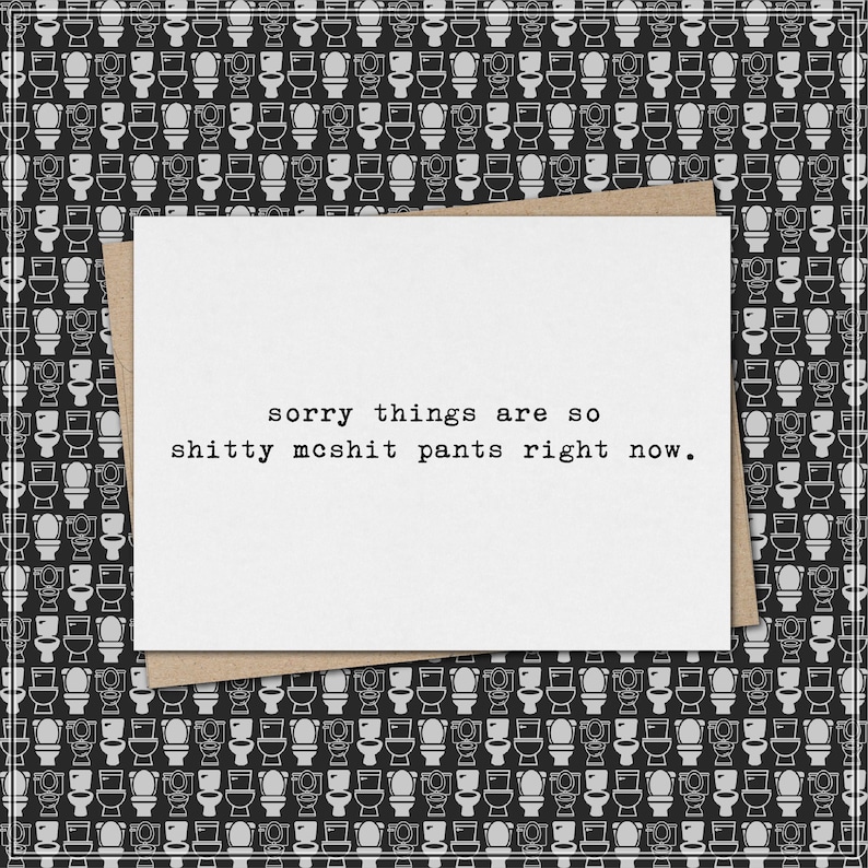May include: A white greeting card with the text "sorry things are so shitty mcshit pants right now." is placed on a brown envelope. The background features a repeating pattern of black and white toilet illustrations.