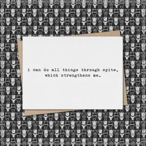 May include: A white greeting card with the text "I can do all things through spite, which strengthens me." is placed on a brown envelope. The background features a black and white pattern of toilet illustrations.