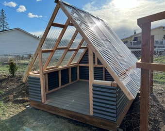 May include: A small wooden structure with a corrugated plastic roof and metal siding. The structure has a wooden frame and a raised platform floor.