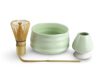 May include: A green ceramic matcha bowl, a bamboo whisk, a green ceramic teacup, and a bamboo matcha scoop. The set is for preparing and drinking matcha tea.