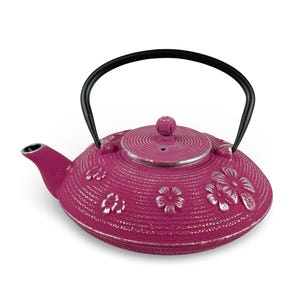 May include: A magenta cast iron teapot with a black handle and lid. The teapot features a floral design with silver accents. The teapot is designed for brewing tea and has a spout for pouring.