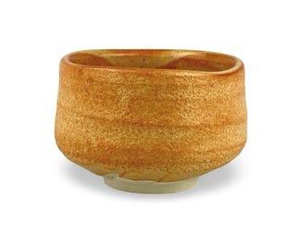 May include: A handcrafted, square-shaped ceramic bowl with a textured, speckled surface. The bowl has a warm, earthy color palette of tan and brown, with a light-colored base. This unique piece is ideal for serving or display.