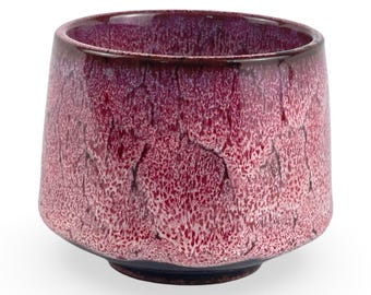 May include: A deep red ceramic teacup with a textured, crackled glaze. The cup has a wide, rounded base and a slightly flared rim.