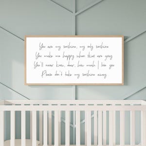 Puede incluir: Un letrero de pared rectangular con un marco de madera clara y un fondo blanco que presenta texto negro en cursiva: You are my sunshine, my only sunshine. You make me happy when skies are gray. You'll never know, dear, how much I love you. Please don't take my sunshine away.