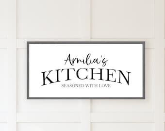 May include: A white sign with a gray frame reads "Amelia's Kitchen Seasoned with Love".
