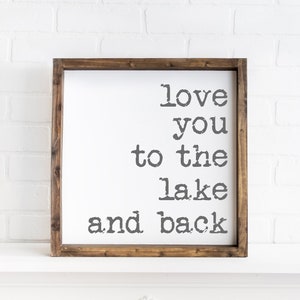 May include: A wooden sign with the text "love you to the lake and back" in a vintage typewriter font.