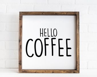 May include: A wooden framed sign with the text "Hello Coffee" in black lettering on a white background.