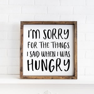 May include: A wooden framed sign with white background and black text that reads "I'm sorry for the things I said when I was hungry".