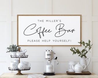 May include: A white sign with black text that reads "The Miller's Coffee Bar Please Help Yourself!"  The sign is hanging on a white wall above a coffee bar with a coffee maker, mugs, and sugar containers.