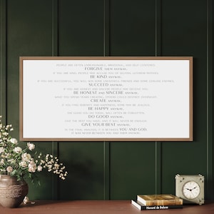 May include: A framed print with a white background and black text. The text is a series of inspirational quotes about forgiveness, kindness, honesty, and success. The quote reads: "People are often unreasonable, irrational, and self-centered. Forgive them anyway. If you are kind, people may accuse you of selfish, ulterior motives. Be kind anyway. If you are successful, you will win some unfaithful friends and some genuine enemies. Succeed anyway. If you are honest and sincere people may deceive you. Be honest and sincere anyway. What you spend years creating, others could destroy overnight. Create anyway. If you find serenity and happiness, some may be jealous. Be happy anyway. The good you do today, will often be forgotten. Do good anyway. Give the best you have, and it will never be enough. Give your best anyway. In the final analysis, it is between you and God. It was never between you and them anyway."