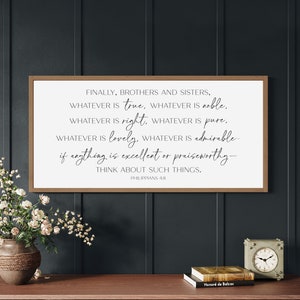 May include: A framed wood sign with a white background and black text. The text reads "Finally, brothers and sisters, whatever is true, whatever is noble, whatever is right, whatever is pure, whatever is lovely, whatever is admirable, if anything is excellent or praiseworthy - think about such things. Philippians 4:8".