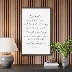May include: A black framed print with a white background and black text. The text reads "By wisdom a house is built, and by understanding it is established. Through knowledge its rooms are filled with rare and beautiful treasures. Proverbs 24:3-4"