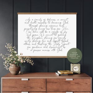 May include: A rectangular wall hanging featuring a white canvas with black cursive text that reads: As a family of believers, we commit and devote ourselves to honouring God through showing reverence and prioritising living our lives for Him.