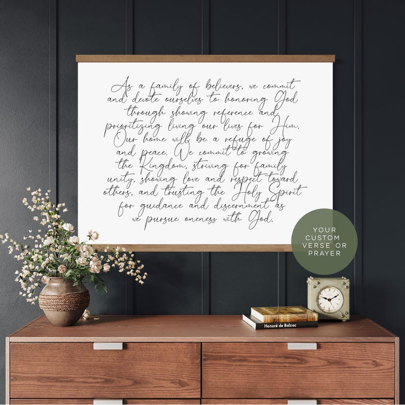 May include: A rectangular wall hanging featuring a white canvas with black cursive text that reads: As a family of believers, we commit and devote ourselves to honouring God through showing reverence and prioritising living our lives for Him.