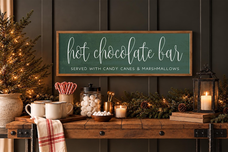 May include: A rectangular wooden-framed sign with a dark green background and white text that reads hot chocolate bar SERVED WITH CANDY CANES & MARSHMALLOWS in a mix of cursive and block lettering, mounted on a dark paneled wall.