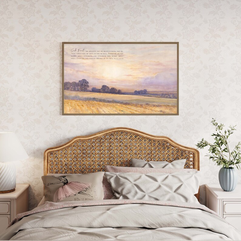 A framed print with a watercolor painting of a field with trees and a sunset sky. The print includes the text "Seek First His Kingdom and His Righteousness, and all these things shall be added unto you." Matthew 6:33.