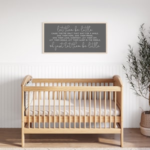 Op de afbeelding: Een rechthoekig wandbord met een lichthouten lijst en een donkergrijze achtergrond met witte tekst die luidt: let them be little, CAUSE THEY'RE ONLY THAT WAY FOR A WHILE. GIVE THEM HOPE, GIVE THEM PRAISE, GIVE THEM LOVE, EVERYDAY. LET THEM CRY, LET THEM GIGGLE, LET THEM SLEEP IN THE MIDDLE. oh just let them be little.