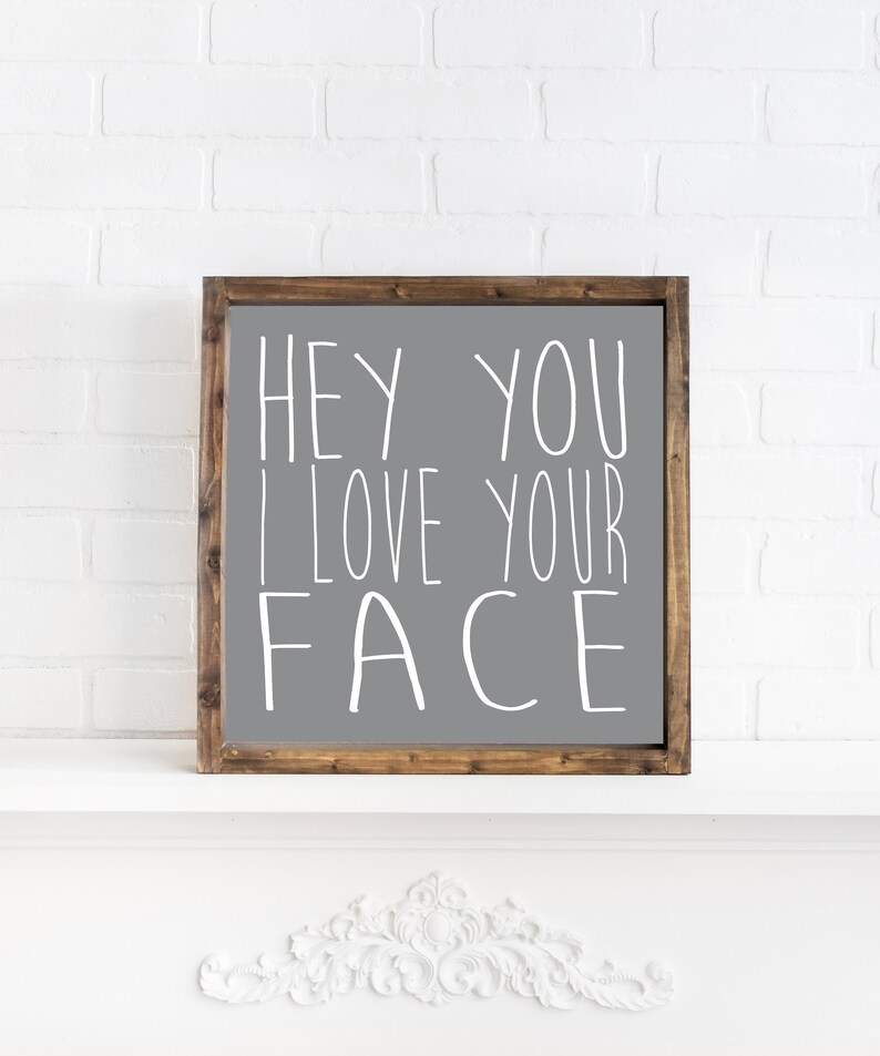 K&ouml;nnte beinhalten: Ein graues Holzschild mit einer wei&szlig;en Aufschrift, die "Hey you I love your face" lautet.