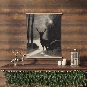 May include: A black and white illustration of a deer standing in a snowy forest. The illustration is framed and hanging on a wooden wall. There are two silver deer figurines and two candles on the mantle below the illustration.