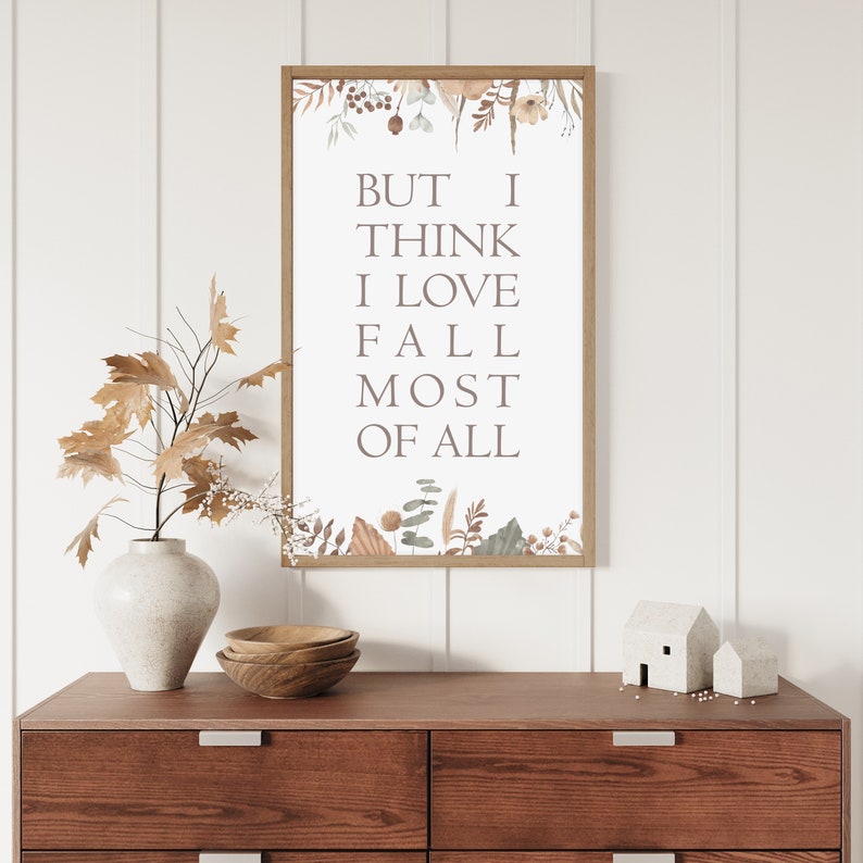 Puede incluir: Un cuadro rectangular enmarcado con el texto BUT I THINK I LOVE FALL MOST OF ALL en una fuente serif. La impresi&oacute;n est&aacute; decorada con ilustraciones en acuarela de hojas secas, ramas y bayas en los bordes superior e inferior.