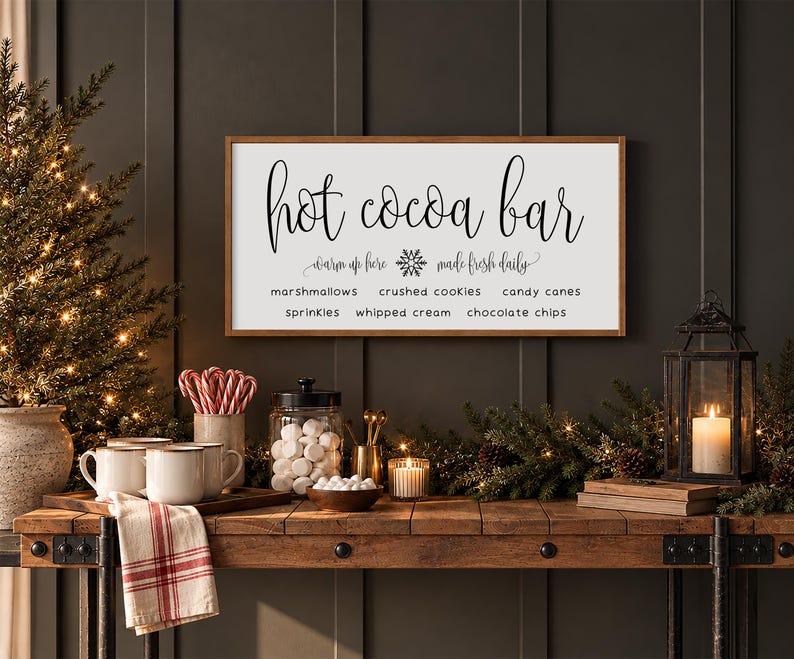 May include: A rectangular white sign with a brown wooden frame featuring the black text Hot Cocoa Bar, warm up here, made fresh daily, and a list of toppings including marshmallows, crushed cookies, candy canes, sprinkles, whipped cream, and chocolate chips.