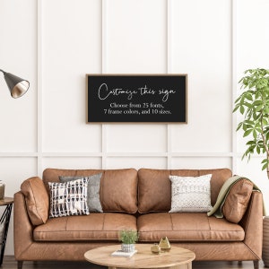 Pu&ograve; includere: Un'insegna da parete rettangolare con sfondo nero e una sottile cornice in legno. L'insegna presenta un testo bianco che recita: Customize this sign. Choose from 25 fonts, 7 frame colors, and 10 sizes. L'insegna &egrave; montata su una parete bianca.