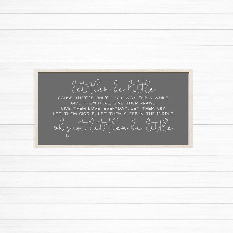 Op de afbeelding: Een rechthoekig wandbord met een lichthouten frame en een donkergrijze achtergrond. Het bord bevat witte tekst die luidt: let them be little, CAUSE THEY'RE ONLY THAT WAY FOR A WHILE. GIVE THEM HOPE, GIVE THEM PRAISE, GIVE THEM LOVE, EVERYDAY. LET THEM CRY, LET THEM GIGGLE, LET THEM SLEEP IN THE MIDDLE. oh just let them be little.