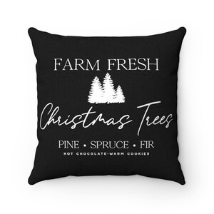 May include: Black throw pillow with white text that reads "FARM FRESH Christmas Trees PINE SPRUCE FIR HOT CHOCOLATE WARM COOKIES". The pillow features a white silhouette of three Christmas trees.