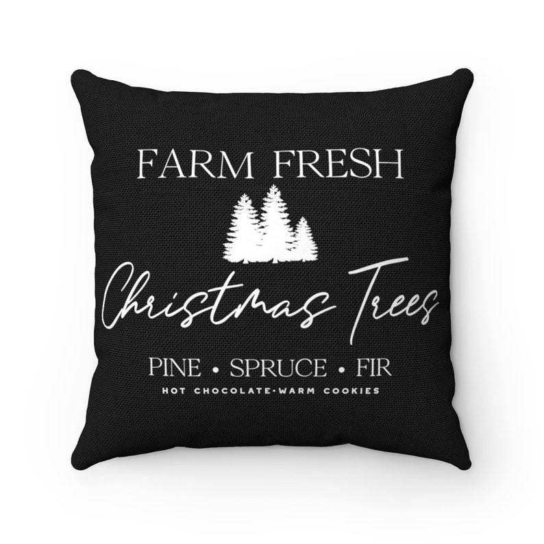 May include: Black throw pillow with white text that reads "FARM FRESH Christmas Trees PINE SPRUCE FIR HOT CHOCOLATE WARM COOKIES". The pillow features a white silhouette of three Christmas trees.